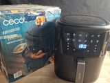 une boîte de nourriture posée sur une table à côté d'une friteuse à air chaud