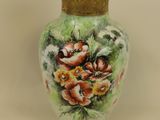 a vase with flowers painted on it sitting on a table