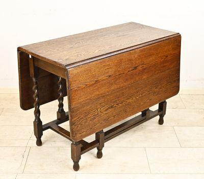an antique oak drop leaf table with turned legs and a drop leaf top