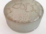 une petite boîte ronde ornée d'un motif floral