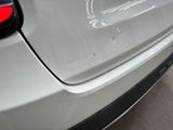 a close up of a car ' s rear bumper with a denting on it