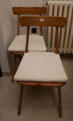 deux chaises en bois et un banc dans une pièce