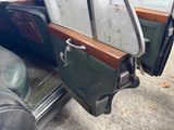 an old car with its door open on the side of the road