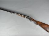 a rifle with a wooden handle on a white surface