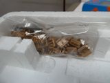 un récipient en plastique rempli de petits morceaux de bois