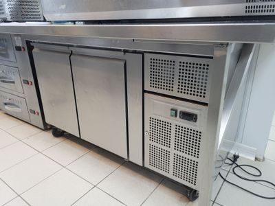 une grande cuisine en inox équipée de nombreux appareils électroménagers