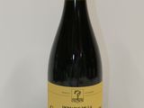une image représentant une bouteille de vin rouge posée sur une table