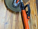 an orange and black corded nail gun sitting on top of a wooden table