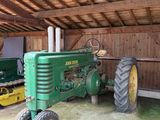 un tracteur vert et un tracteur jaune à l'intérieur d'une grange