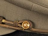 a close up of a hat with a gold button on it