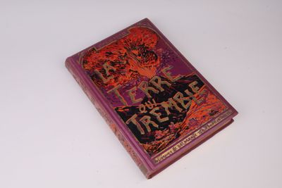 un vieux livre posé sur une table à côté d'une table blanche
