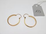 a pair of gold hoop earrings with a price tag