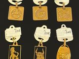 six gold medals and tags of various types on a black surface