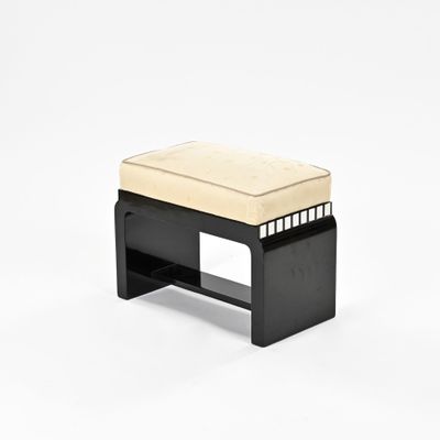 une photo d'un banc noir sur lequel est posé un coussin beige