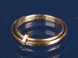 une bague en or ornée d'une croix sur un fond bleu