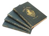 trois livres sont empilés sur une surface blanche