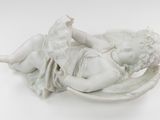 a statue of a child laying down on a pillow