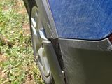a close up of a blue car parked in the grass