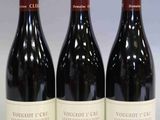 trois bouteilles de vin rouge posées sur une table blanche