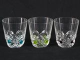 three glasses with different colored stones in them on a black background