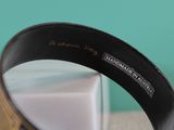 a black and gold bracelet with a name engraved on it