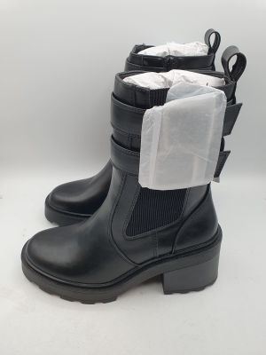 une paire de bottes noires sur lesquelles est posé un sac en plastique