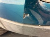 a blue car with a hole in the front of it