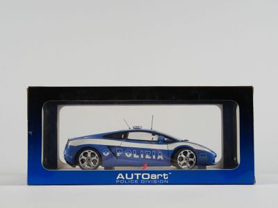une image représentant une voiture de police miniature dans une boîte, posée sur une surface blanche
