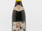 une vieille bouteille de vin posée sur une surface blanche