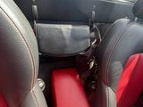 une photo d'une voiture rouge et noire avec des sièges en cuir noir