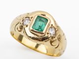 a close up of a gold ring with an emerald and diamonds