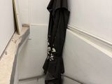 a black umbrella hanging on the wall next to some stairs