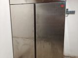 two stainless steel refrigerators in a room with white walls