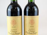 deux bouteilles de vin rouge posées l'une à côté de l'autre sur une surface blanche