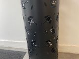 a black vase sitting on the floor next to a wall