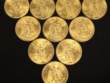 a bunch of gold coins sitting on top of a black surface