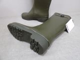 pair of green rubber boots with black soles on a white surface