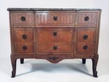 a wooden chest of drawers with marble top