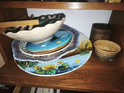 a wooden shelf with plates and bowls and chopsticks on it