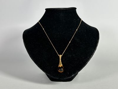a black and gold necklace on a black mannequin
