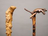 two walking sticks with a cat on top of them