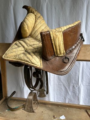 a horse saddle that is sitting on top of a wooden table
