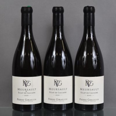 three bottles of wine are lined up on a table