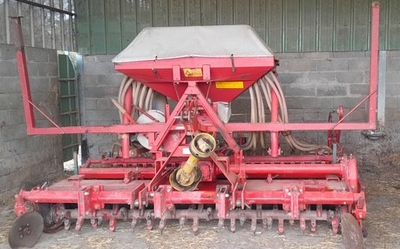 a red machine that is sitting in the dirt
