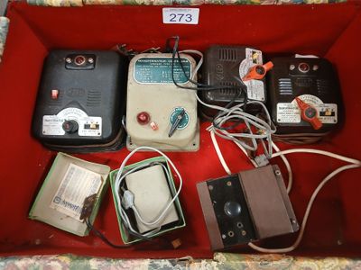 une boîte rouge remplie d'appareils électroniques et de fils, posée par terre