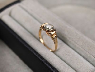 une bague en or sertie d'un diamant, dans un écrin