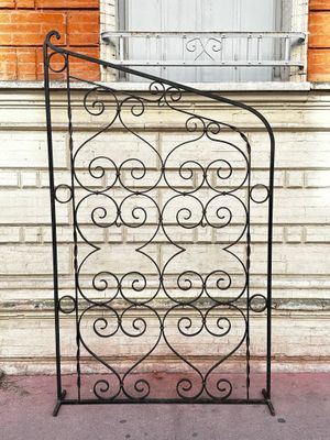 Grille en fer forgé porte-plantes à décor de rinceaux.