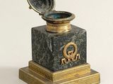 a gold and black marble box with a clock on it