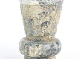 a stone vase that is sitting on top of a table