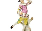une figurine représentant une femme assise sur une branche d'arbre